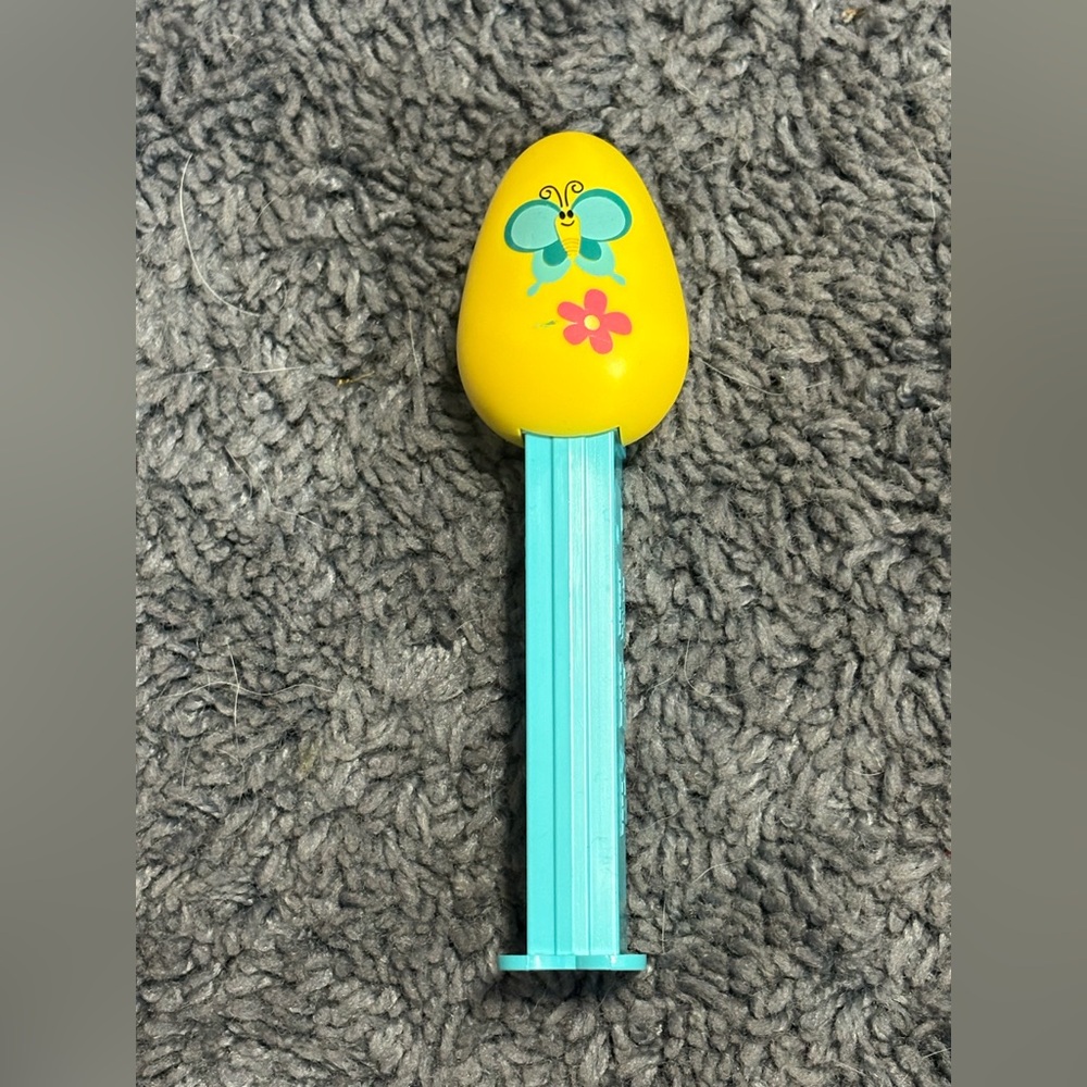 NWOT Blue collectible PEZ dispenser with a yellow egg with a butterfly design